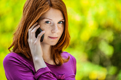 Frau mit Smartphone am Kopf