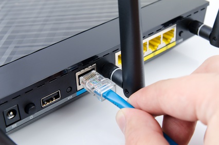 WLAN-Router, an den gerade ein Netzwerkkabel angeschlossen wird